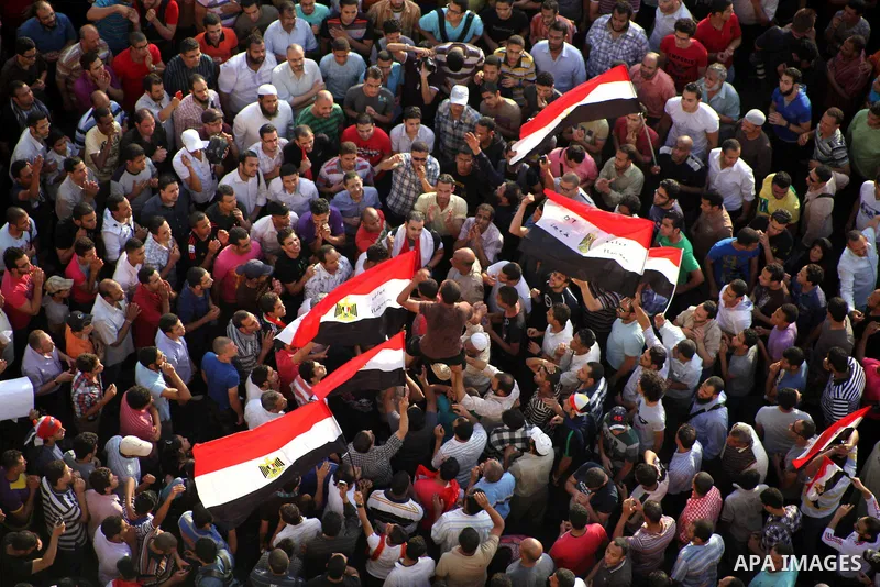 A view taken from a building overviewing Tahrir square shows Egyptian protesters shouting slogans against former President Hosni Mubarak and his aides during a demonstration hours after the announcement of the verdict in...