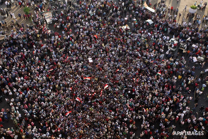 A view taken from a building overviewing Tahrir square shows Egyptian protesters shouting slogans against former President Hosni Mubarak and his aides during a demonstration hours after the announcement of the verdict in...