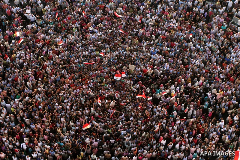 A view taken from a building overviewing Tahrir square shows Egyptian protesters shouting slogans against former President Hosni Mubarak and his aides during a demonstration hours after the announcement of the verdict in...