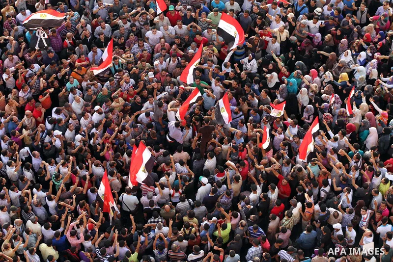 A view taken from a building overviewing Tahrir square shows Egyptian protesters shouting slogans against former President Hosni Mubarak and his aides during a demonstration hours after the announcement of the verdict in...