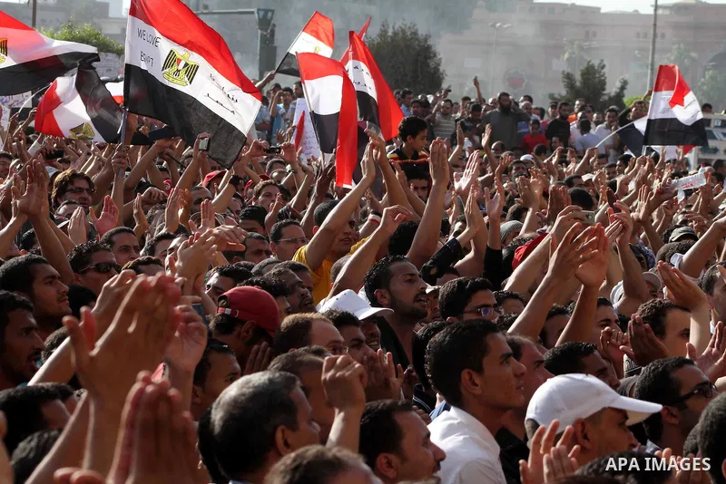 Egyptian protesters hold their national flag and effigies of the heads of former President Hosni Mubarak and his sons during a protest hours after the announcement of the verdict in their trial, in Tahrir square, Cairo,...