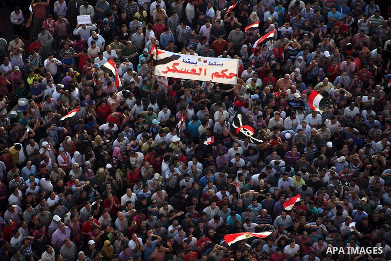 A view taken from a building overviewing Tahrir square shows Egyptian protesters shouting slogans against former President Hosni Mubarak and his aides during a demonstration hours after the announcement of the verdict in...