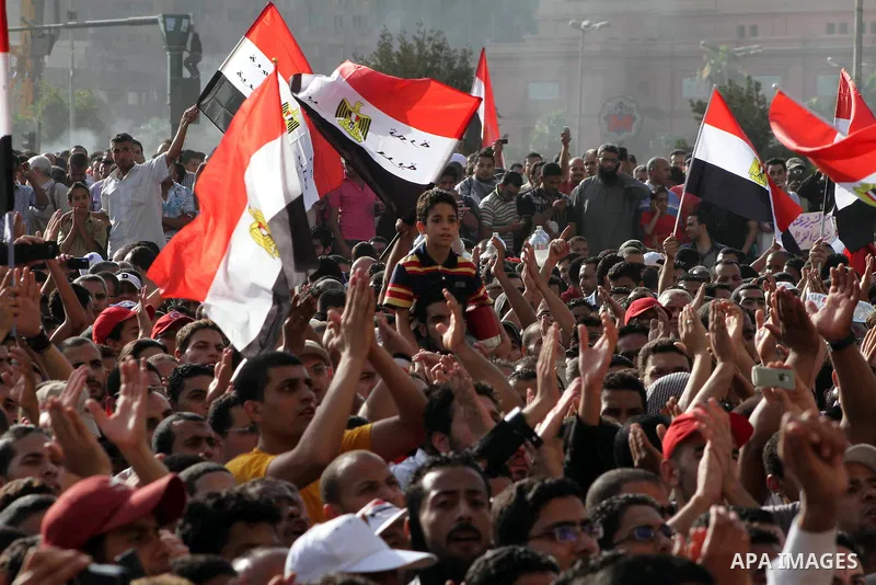 Egyptian protesters hold their national flag and effigies of the heads of former President Hosni Mubarak and his sons during a protest hours after the announcement of the verdict in their trial, in Tahrir square, Cairo,...