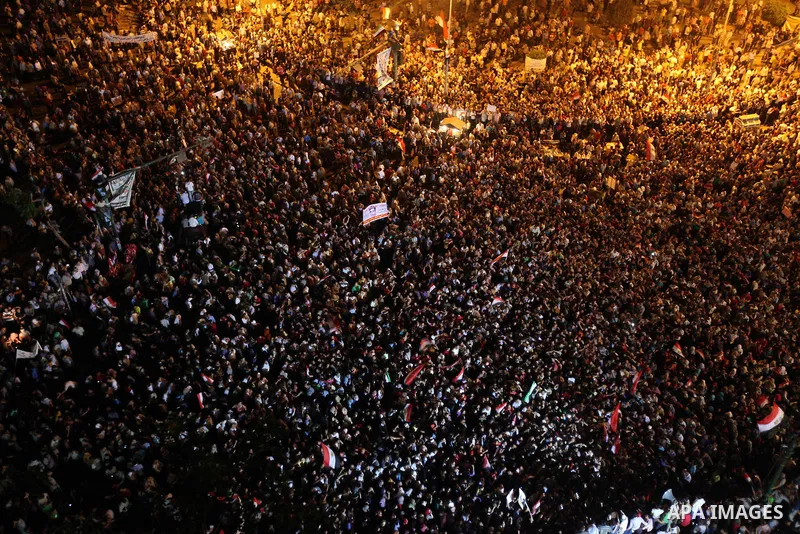 A view taken from a building overviewing Tahrir square shows Egyptian protesters shouting slogans against former President Hosni Mubarak and his aides during a demonstration hours after the announcement of the verdict in...