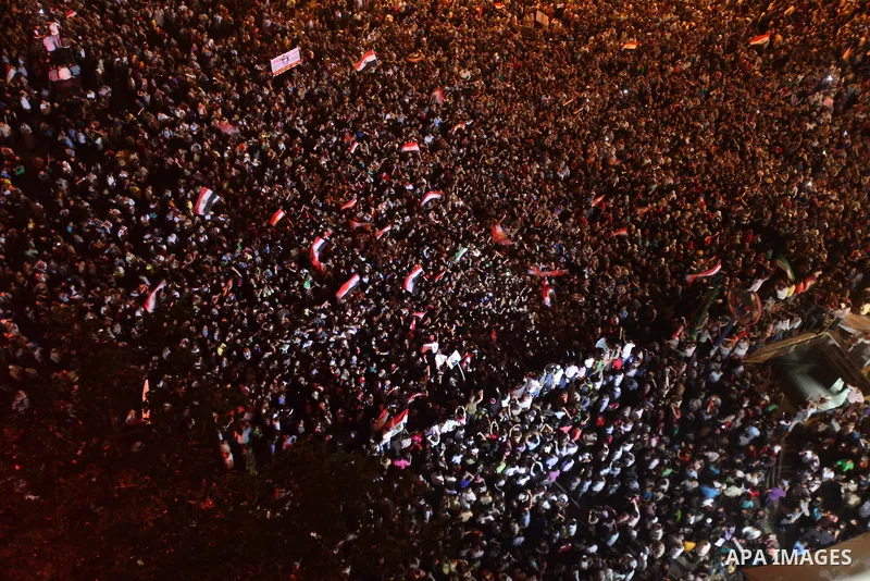 A view taken from a building over viewing Tahrir square shows Egyptian protesters shouting slogans against former President Hosni Mubarak and his aides during a demonstration hours after the announcement of the verdict i...