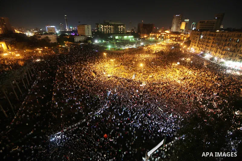 A view taken from a building over viewing Tahrir square shows Egyptian protesters shouting slogans against former President Hosni Mubarak and his aides during a demonstration hours after the announcement of the verdict i...