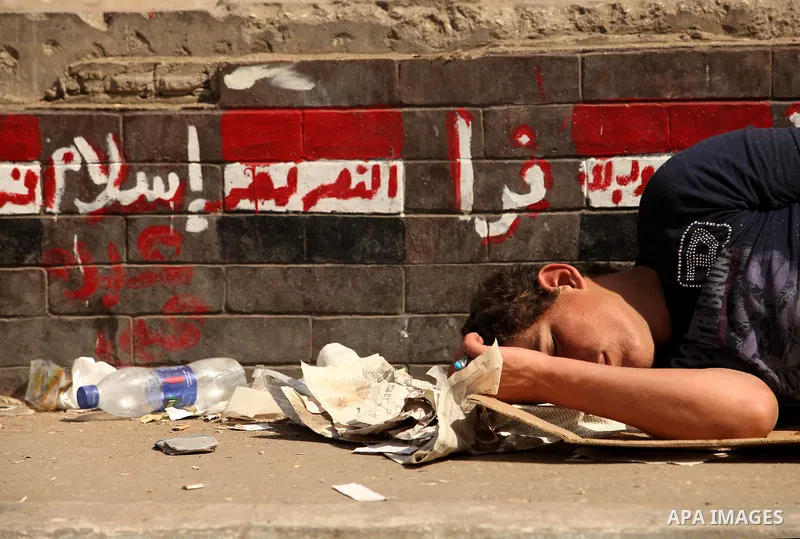 An Egyptian man sleeps on the ground in Cairo's landmark Tahrir Square on June 3, 2012 after a night of protests. Hundreds of demonstrators are occupying Tahrir Square after a court sentenced ousted president Hosni Mubar...