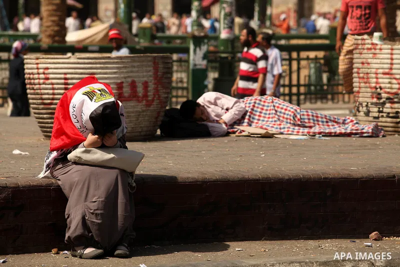 Egyptian men sleep on the ground in Cairo's landmark Tahrir Square on June 3, 2012 after a night of protests. Hundreds of demonstrators are occupying Tahrir Square after a court sentenced ousted president Hosni Mubarak a...
