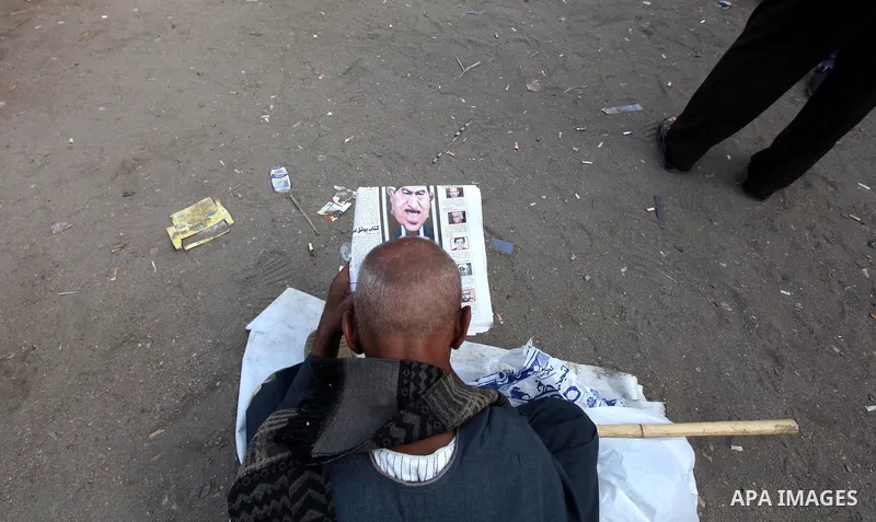 An Egyptian man read Egyptian newspapers in Cairo's landmark Tahrir Square on June 3, 2012 after a night of protests. Hundreds of demonstrators are occupying Tahrir Square after a court sentenced ousted president Hosni M...