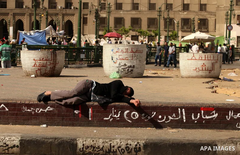 An Egyptian man sleeps on the ground in Cairo's landmark Tahrir Square on June 3, 2012 after a night of protests. Hundreds of demonstrators are occupying Tahrir Square after a court sentenced ousted president Hosni Mubar...