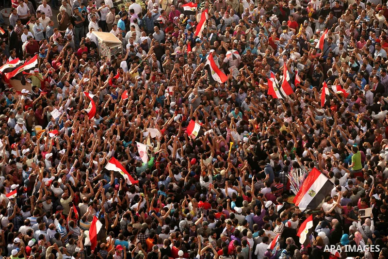Egyptian preacher and member of the Muslim Brotherhood Safwat el-Hegazy is carried up by protesters as he joins them in a demonstration a day after a court sentenced deposed president Hosni Mubarak to life in prison, at...
