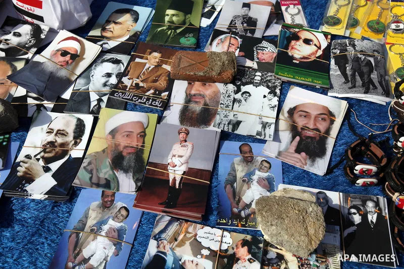 An Egyptian displays pictures for Arab figures during a demonstration a day after a court sentenced deposed president Hosni Mubarak to life in prison, at Tahrir Square in Cairo June 3, 2012. Egyptian pro-democracy campai...