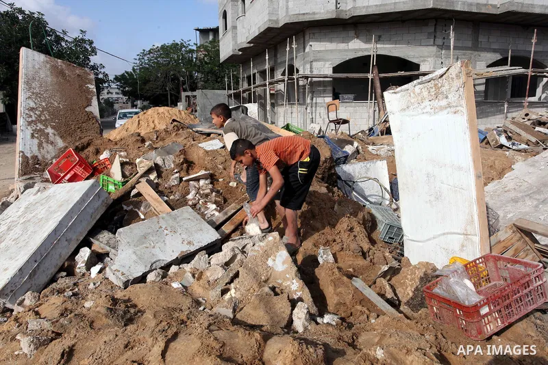Palestinian boys inspect the damage at a cheese factory in Gaza City on June 4, 2012 following an Israeli air strike on the Gaza Strip on June 3. Emergency medical sources in Gaza said seven Palestinians were wounded in...