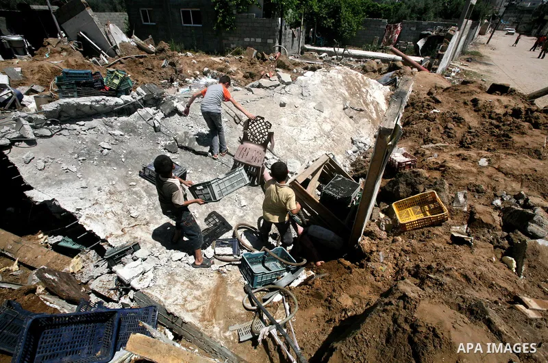 Palestinian boys inspect the damage at a cheese factory in Gaza City on June 4, 2012 following an Israeli air strike on the Gaza Strip on June 3. Emergency medical sources in Gaza said seven Palestinians were wounded in...
