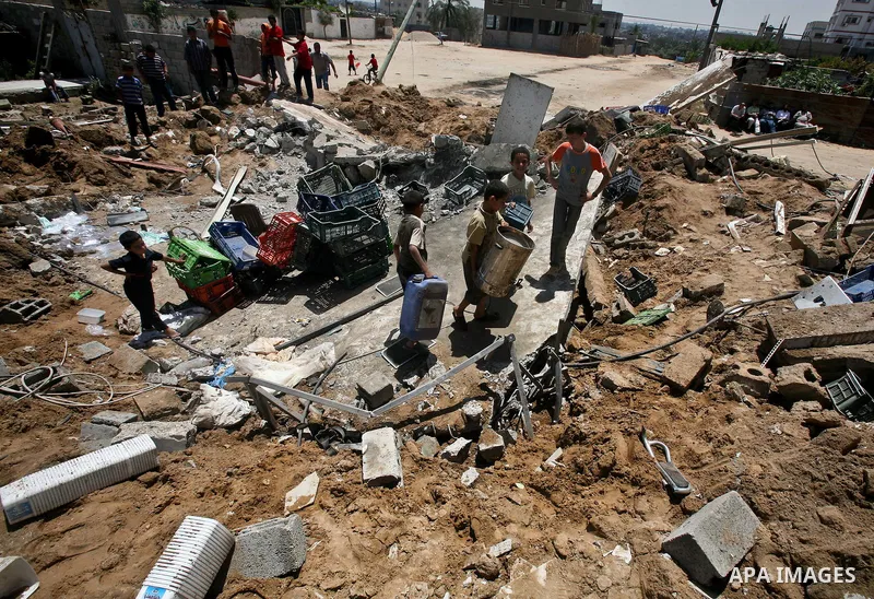 Palestinian boys inspect the damage at a cheese factory in Gaza City on June 4, 2012 following an Israeli air strike on the Gaza Strip on June 3. Emergency medical sources in Gaza said seven Palestinians were wounded in...
