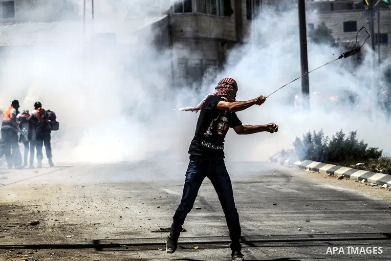 A Palestinian protester throws stones at Israeli soldiers during clashes at the entrance to Ofer prison, near the West Bank city of Ramallah, on June 5, 2012 following a demonstration to mark "Naksa Day", the 44th annive...