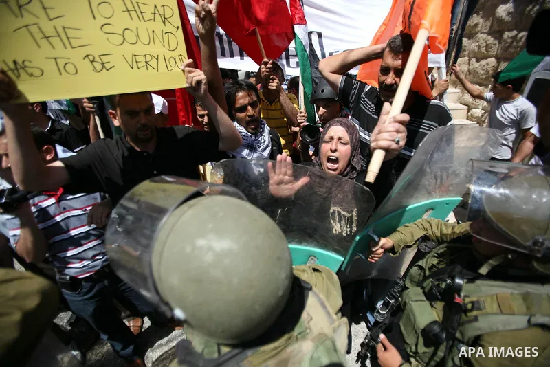 Palestinian protesters hold flags and banners during a demonstration against the Israeli occupation and to mark "Naksa Day", the 44th anniversary of the 1967 Six Day War, at the entrance of the old city near the settleme...