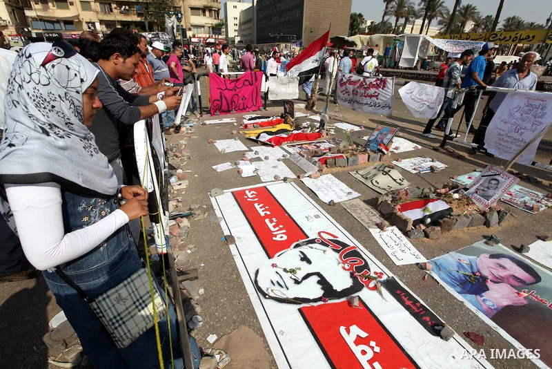 Egyptians protesters stand in front pictures of Revolution martyrs during a demonstration at Tahrir square in Cairo June 5, 2012. Activists urged Egyptians to turn out for a big protest on Tuesday to reclaim a revolt the...