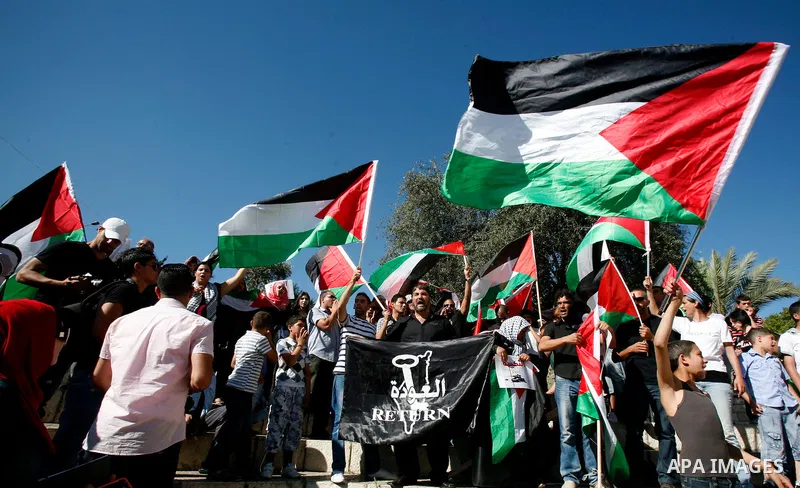 Palestinian protesters hold flags during a demonstration marking the 'Naksa Day' at the Damascus Gate on 05 June 2012. Naksa Day is the annual day of commemoration for the Palestinian people of the displacement that acco...
