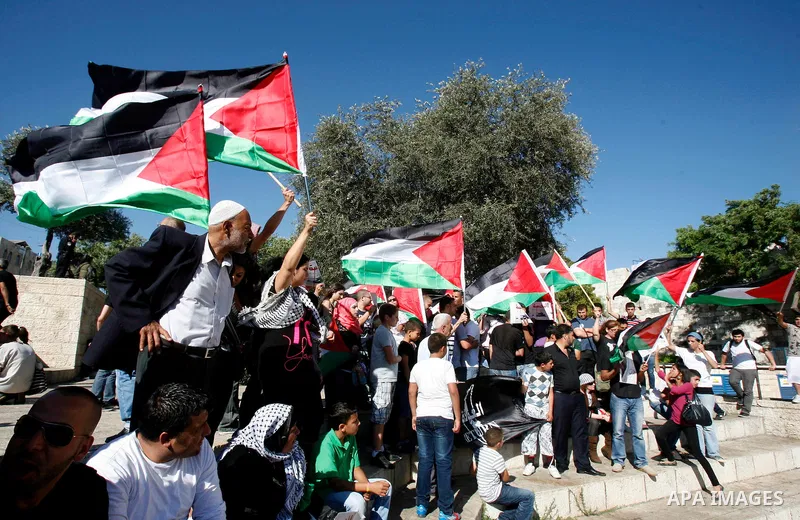 Palestinian protesters hold flags during a demonstration marking the 'Naksa Day' at the Damascus Gate on 05 June 2012. Naksa Day is the annual day of commemoration for the Palestinian people of the displacement that acco...