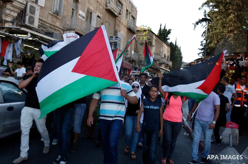 Palestinian protesters hold flags during a demonstration marking the 'Naksa Day' at the Damascus Gate on 05 June 2012. Naksa Day is the annual day of commemoration for the Palestinian people of the displacement that acco...