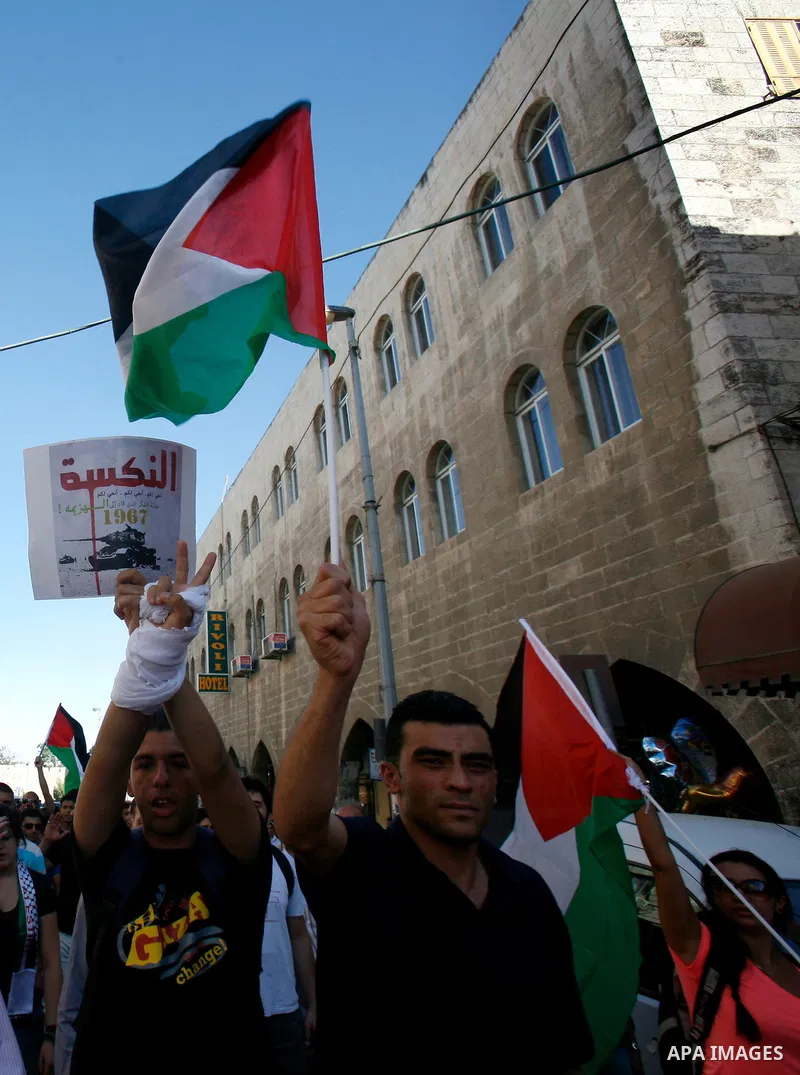 Palestinian protesters hold flags during a demonstration marking the 'Naksa Day' at the Damascus Gate on 05 June 2012. Naksa Day is the annual day of commemoration for the Palestinian people of the displacement that acco...