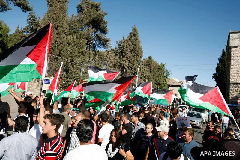 Palestinian protesters hold flags during a demonstration marking the 'Naksa Day' at the Damascus Gate on 05 June 2012. Naksa Day is the annual day of commemoration for the Palestinian people of the displacement that acco...