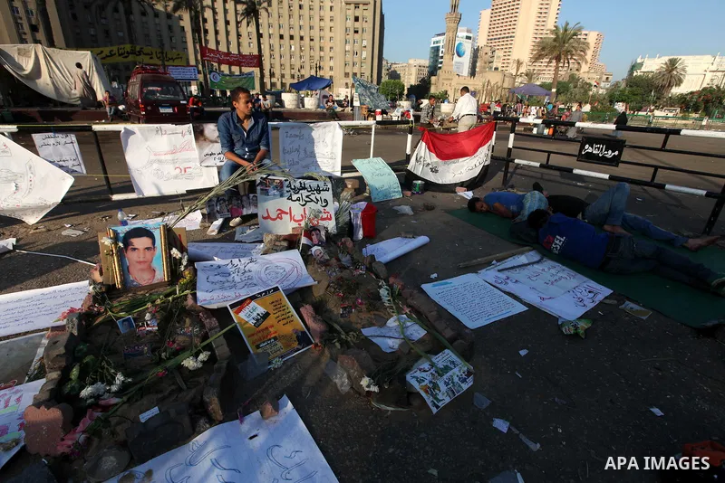 Egyptians protester sleep on the street under mural in Cairo's landmark Tahrir Square on June 6, 2012, as people demonstrated to protest against verdicts handed down in ex-president Hosni Mubarak's murder trial. Photo by...