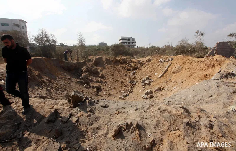 Palestinians inspect the damage at agricultural land in Al Sudania area in the northern Gaza Strip on June 6, 2012 following an Israeli air strike on the Gaza Strip. Photo by Ashraf Amra