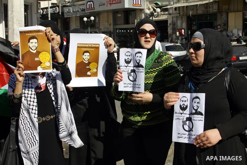 Palestinian protestors hold pictures of Palestinian prisoners Mahmoud al-Sarsak and Akram al-Rikhawi, whose are still refusing food for 80 days after a deal was made to end a mass prisoner hunger strike, during a demonst...