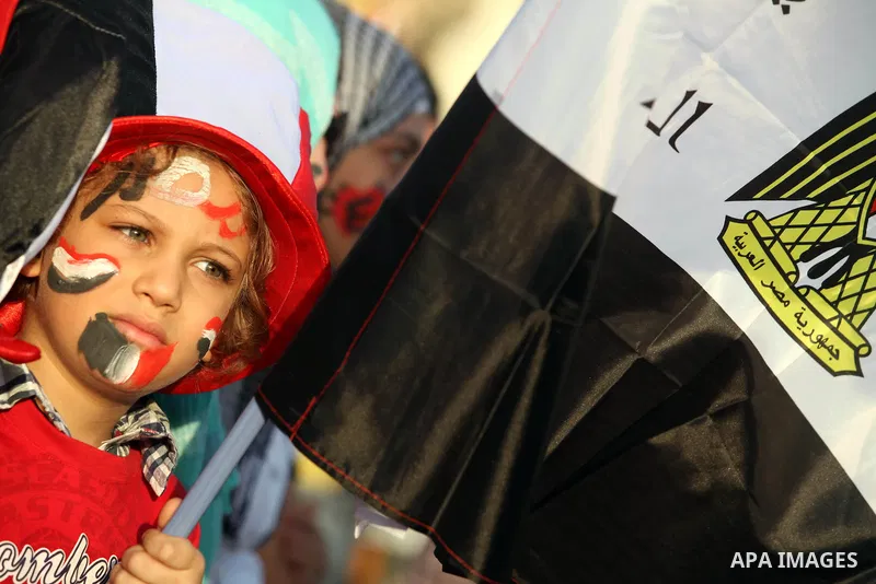 Egyptian girl wears a hat decorated with national flag during a demonstration in Cairo's landmark Tahrir Square on June 6, 2012 to protest against verdicts handed down in ex-president Hosni Mubarak's murder trial. Mubara...