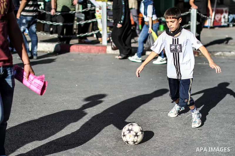 Palestinian child plays football in the streets of Ramallah during a rally solidarity with Palestinian prisoner Mahmoud Al-Sarsak who is still refusing food after a deal was made to end a mass prisoner hunger strike, on...