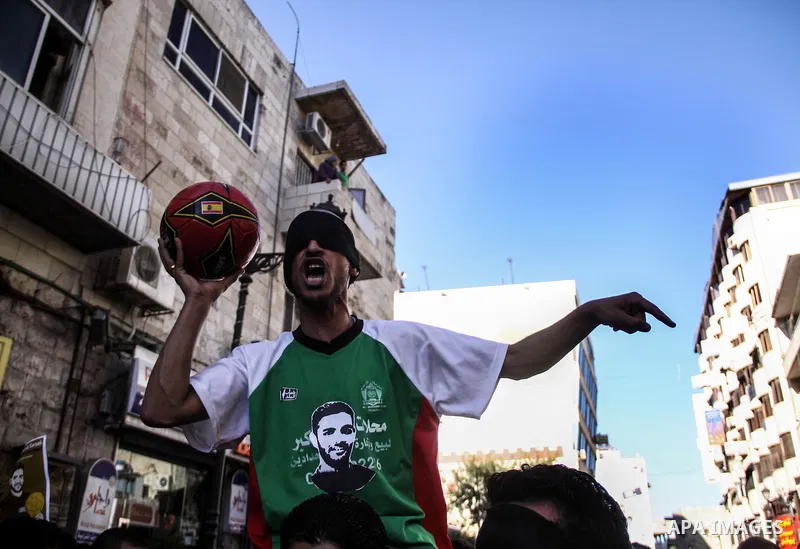 Palestinian youth play football in the streets of Ramallah during a rally solidarity with Palestinian prisoner Mahmoud Al-Sarsak who is still refusing food after a deal was made to end a mass prisoner hunger strike, on 0...