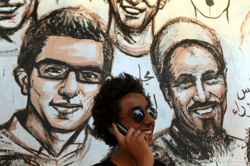 An Egyptian talks on mobile, in front of a mural in Cairo's Tahrir square on June 7, 2012. Thousands of Egyptians flocked to Cairo's iconic Tahrir square and other places on Thursday to protest the verdict handed down in...
