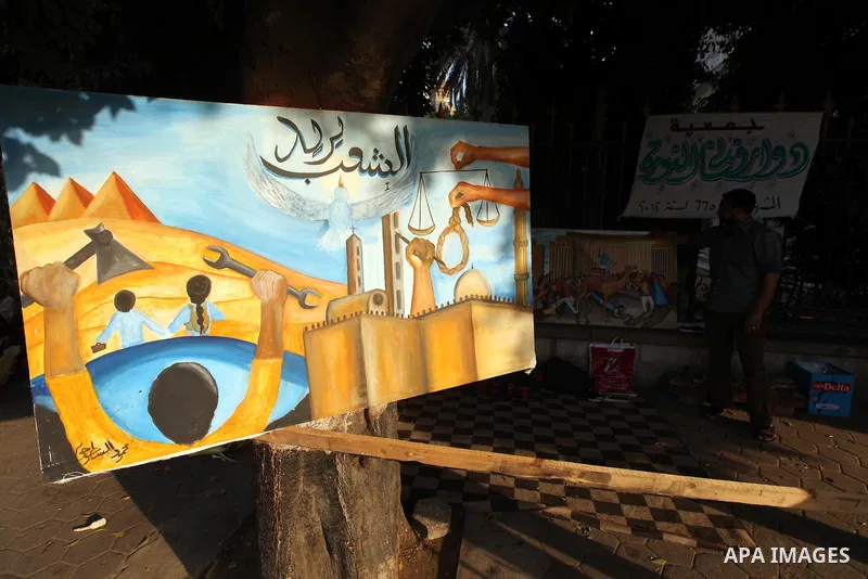 An Egyptian holds a picture supporting revolution in Cairo's Tahrir square on June 7, 2012. Thousands of Egyptians flocked to Cairo's iconic Tahrir square and other places on Thursday to protest the verdict handed down i...