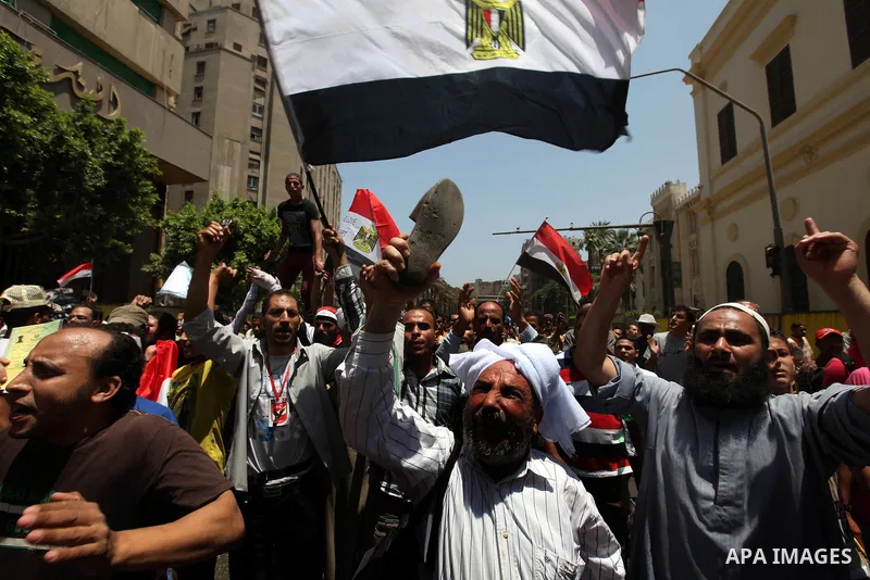 Egyptian protesters wave national flags during a demonstration against presidential candidate Ahmed Shafiq in central Cairo's Tahrir Square, as hundreds of people gathered after the Friday noon prayer on June 8, 2012 in...
