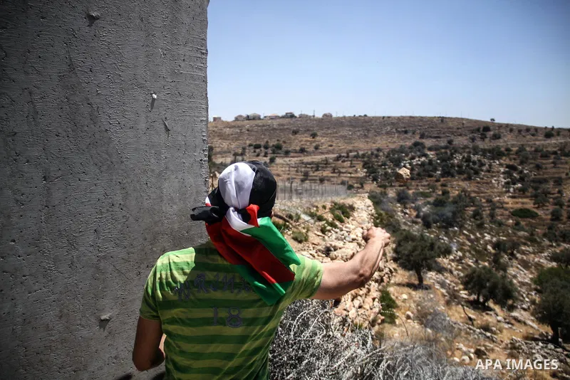 Palestinian protester hurls stones at Israeli soldiers during a weekly demonstration against Israel's controversial separation barrier in the West Bank village of Nilin on June 8, 2012. When completed, 85 percent of the...