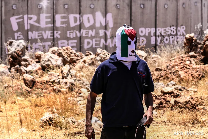 Palestinian protester hurls stones at Israeli soldiers during a weekly demonstration against Israel's controversial separation barrier in the West Bank village of Nilin on June 8, 2012. When completed, 85 percent of the...