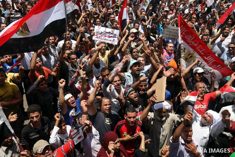 Egyptian protesters wave national flags during a demonstration against presidential candidate Ahmed Shafiq in central Cairo's Tahrir Square, as hundreds of people gathered after the Friday noon prayer on June 8, 2012 in...