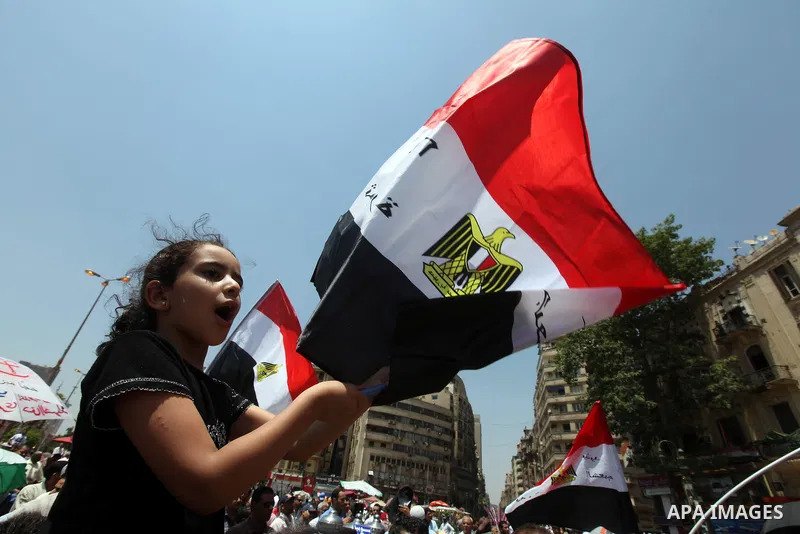 Egyptian protesters wave national flags during a demonstration against presidential candidate Ahmed Shafiq in central Cairo's Tahrir Square, as hundreds of people gathered after the Friday noon prayer on June 8, 2012 in...