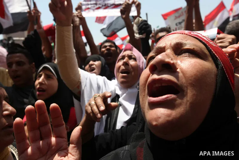 Egyptian protesters wave national flags during a demonstration against presidential candidate Ahmed Shafiq in central Cairo's Tahrir Square, as hundreds of people gathered after the Friday noon prayer on June 8, 2012 in...