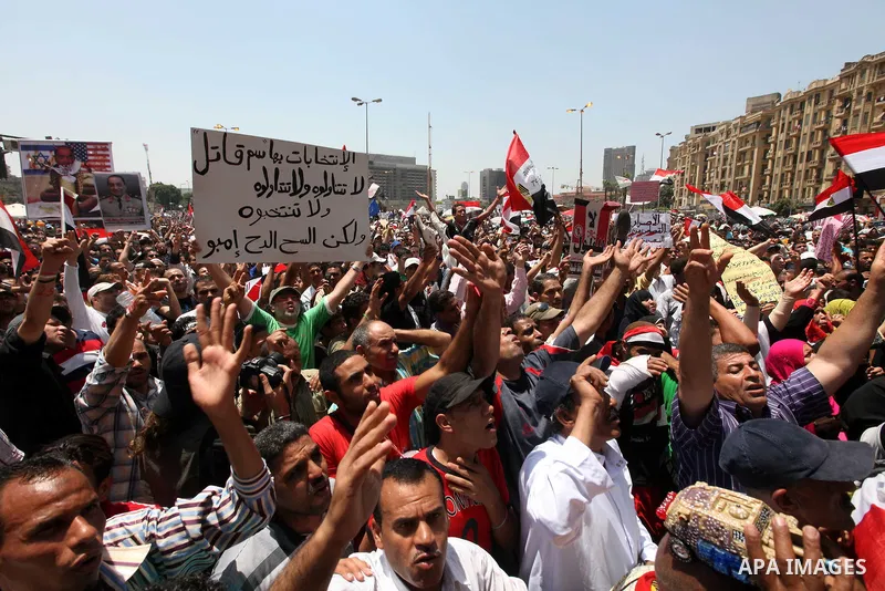 Egyptian protesters wave national flags during a demonstration against presidential candidate Ahmed Shafiq in central Cairo's Tahrir Square, as hundreds of people gathered after the Friday noon prayer on June 8, 2012 in...