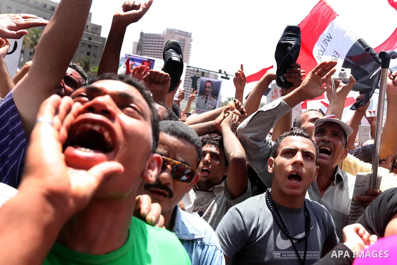 Egyptian protesters wave national flags during a demonstration against presidential candidate Ahmed Shafiq in central Cairo's Tahrir Square, as hundreds of people gathered after the Friday noon prayer on June 8, 2012 in...