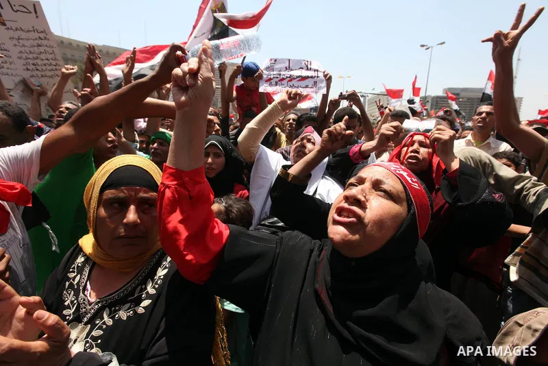 Egyptian protesters wave national flags during a demonstration against presidential candidate Ahmed Shafiq in central Cairo's Tahrir Square, as hundreds of people gathered after the Friday noon prayer on June 8, 2012 in...