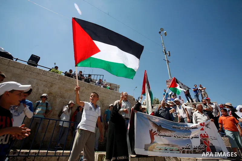 Palestinians hold national flag and shout slogans during a protest against continuing of 'Judaization of Jerusalem' by Jewish settlers and confiscating Palestinian lands at Damascus gate after Friday prayer in east jerus...