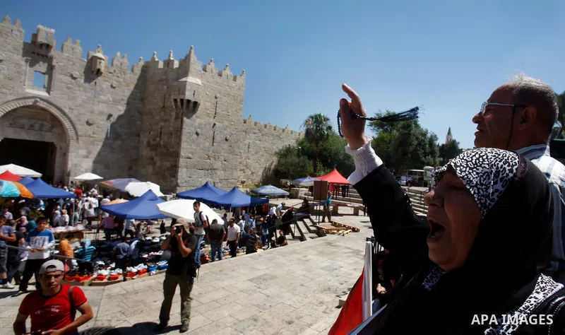 Palestinians hold national flag and shout slogans during a protest against continuing of 'Judaization of Jerusalem' by Jewish settlers and confiscating Palestinian lands at Damascus gate after Friday prayer in east jerus...