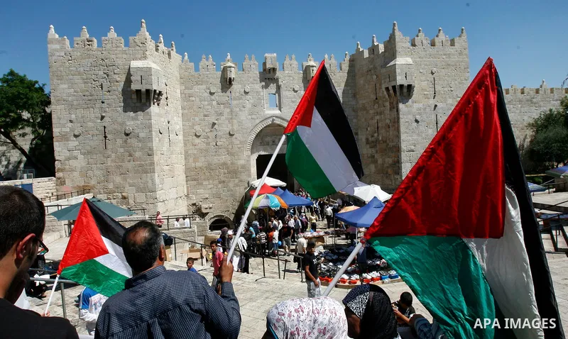 Palestinians hold national flag and shout slogans during a protest against continuing of 'Judaization of Jerusalem' by Jewish settlers and confiscating Palestinian lands at Damascus gate after Friday prayer in east jerus...