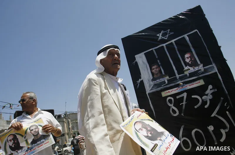 Palestinians hold posters depicting prisoners Mahmoud Al-Sarsak, and Akram al-Rekhawi during a rally in solidarity with them, in Rafah, in the southern Gaza Strip June 9, 2012. Al-Sarsak and al-Rekhawi, two Palestinian p...