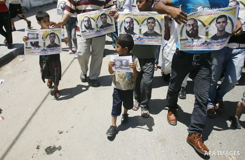 Palestinians hold posters depicting prisoners Mahmoud Al-Sarsak, and Akram al-Rekhawi during a rally in solidarity with them, in Rafah, in the southern Gaza Strip June 9, 2012. Al-Sarsak and al-Rekhawi, two Palestinian p...