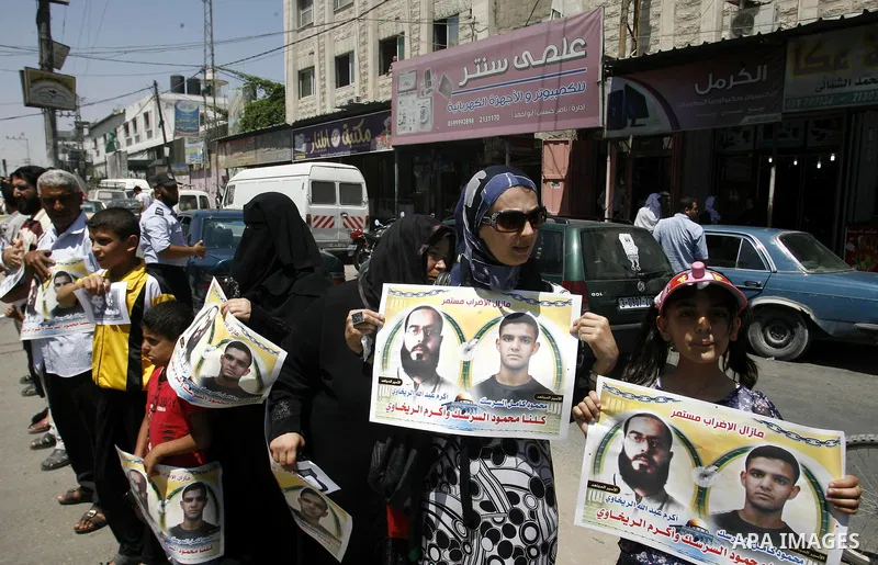 Palestinians hold posters depicting prisoners Mahmoud Al-Sarsak, and Akram al-Rekhawi during a rally in solidarity with them, in Rafah, in the southern Gaza Strip June 9, 2012. Al-Sarsak and al-Rekhawi, two Palestinian p...